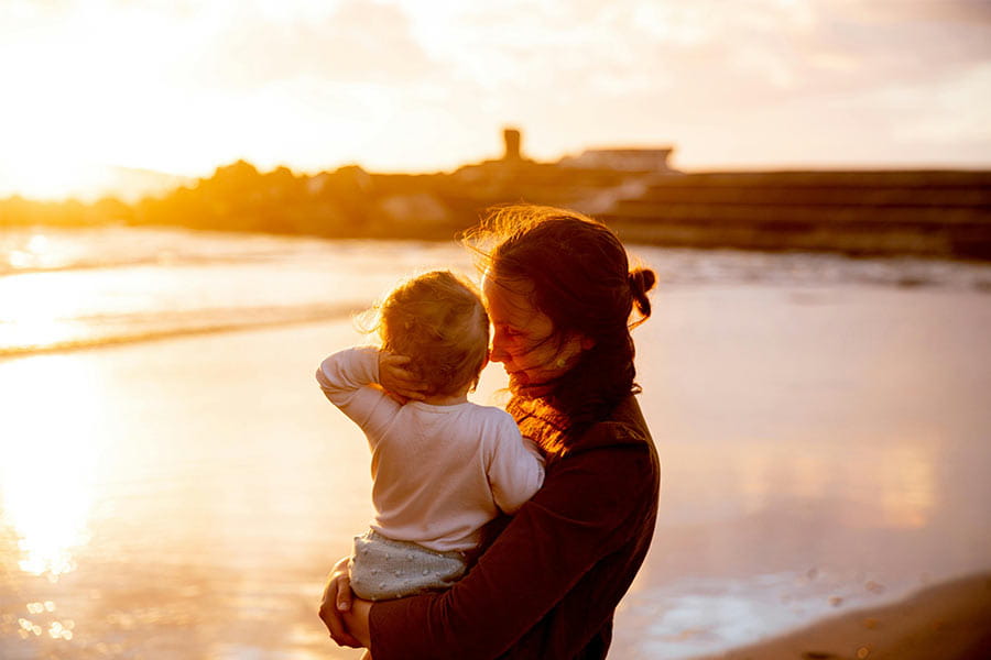 mother watching the sunset with her child