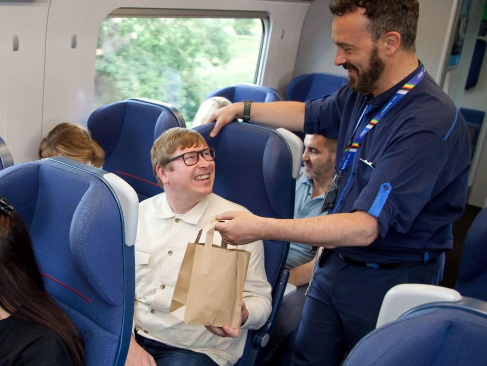 lumo staff handing passenger LumoEats food