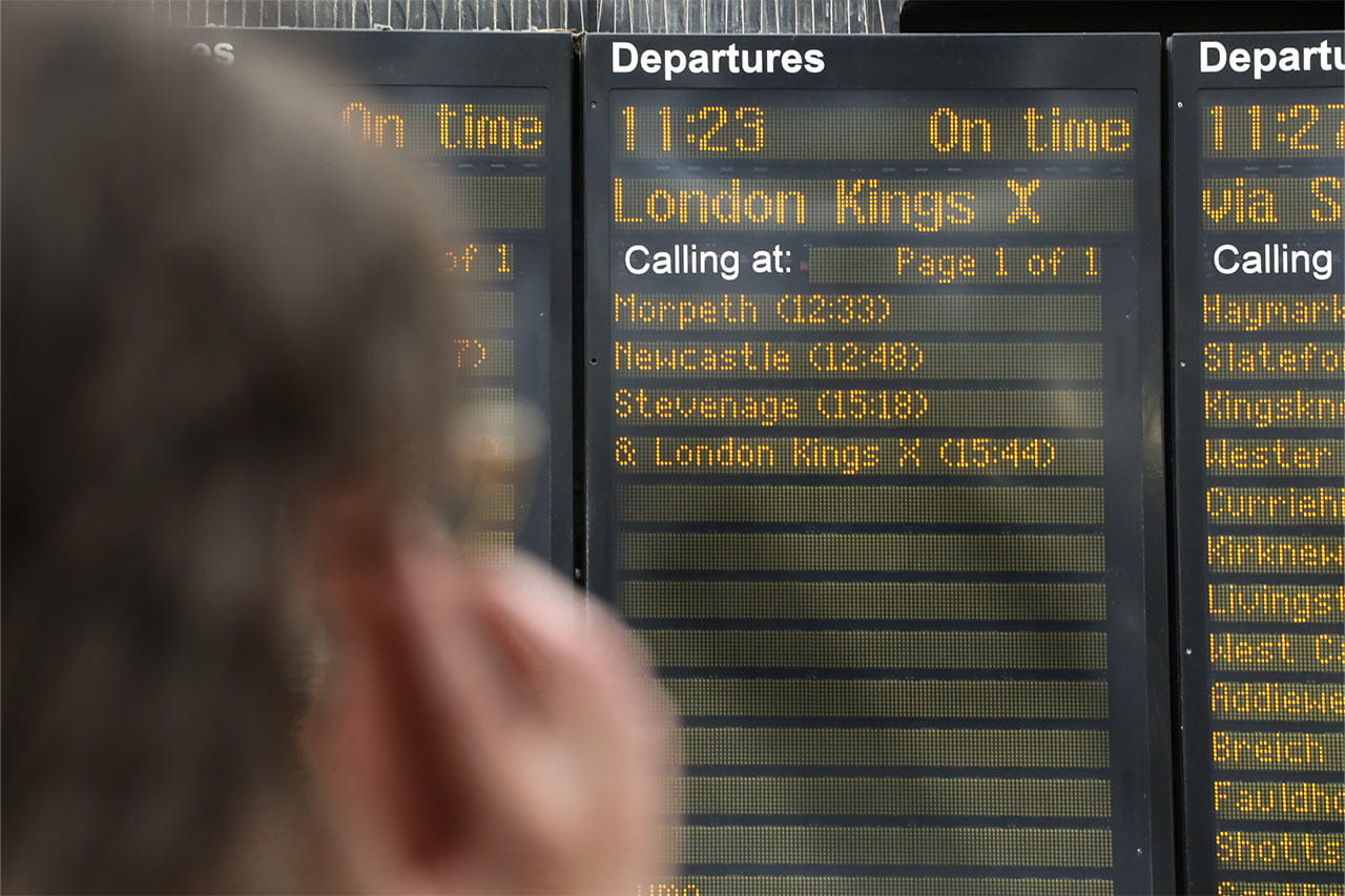 a person looking at train departure board