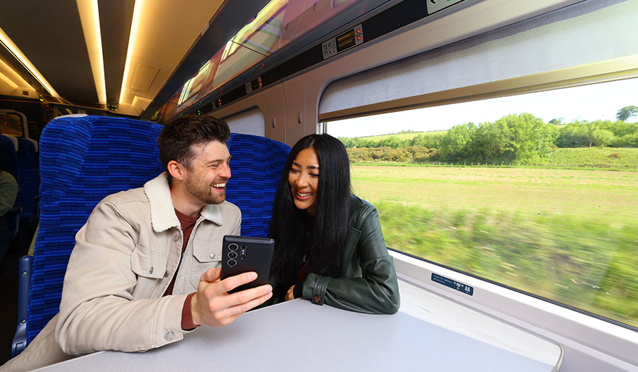 Two passengers staring at their phone