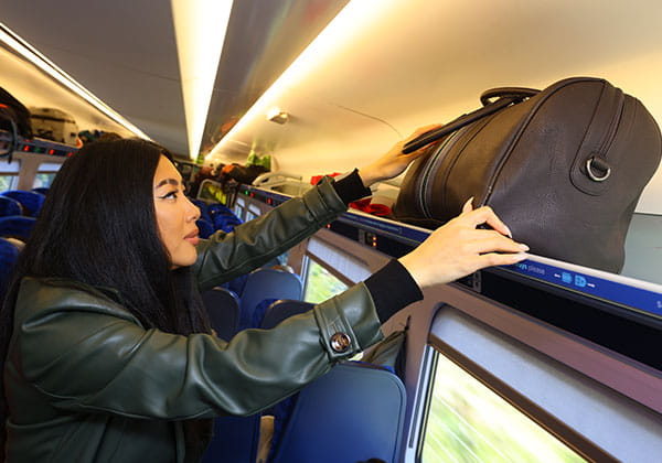 Customer storing luggage in overhead rack