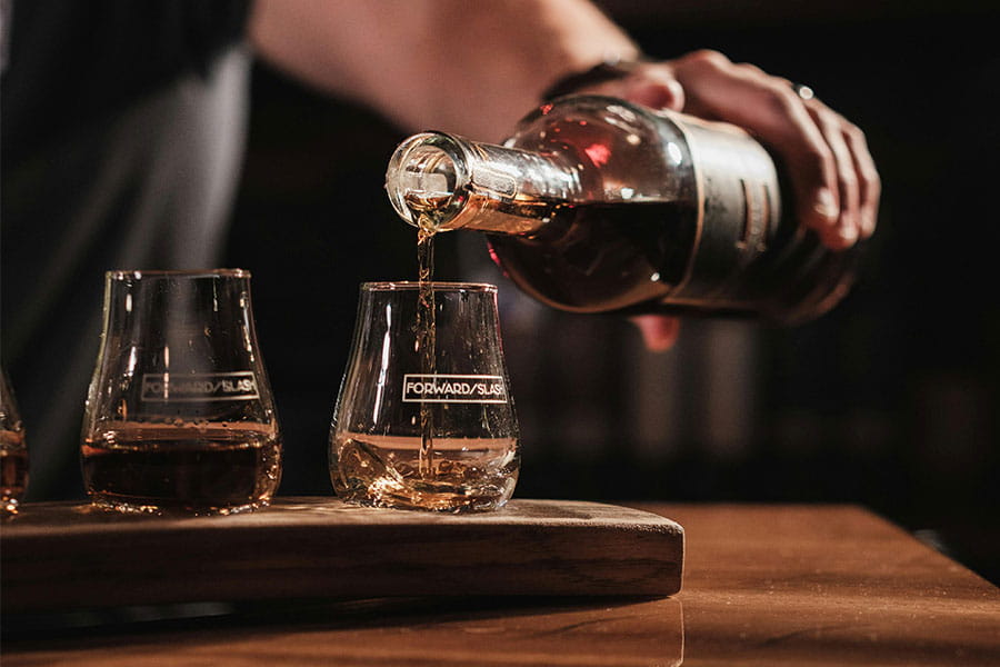 Person pouring whisky in a glass