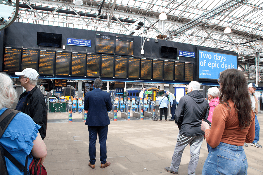 Customers checking departure board at Edinburgh Waverley
