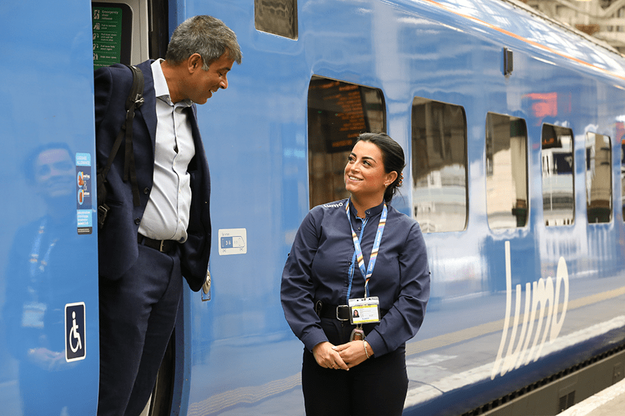 Lumo staff greeting passenger on Lumo train