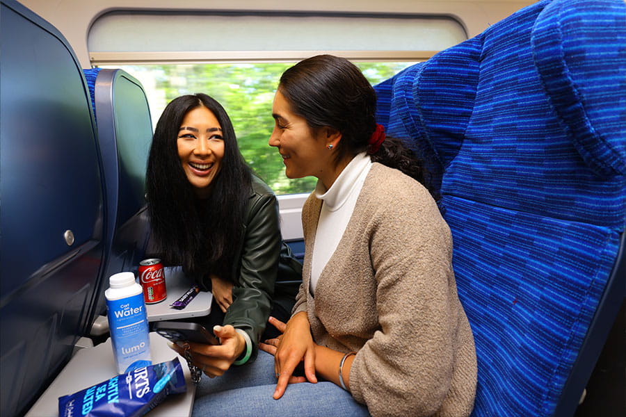 Two passengers laughing on a Lumo train