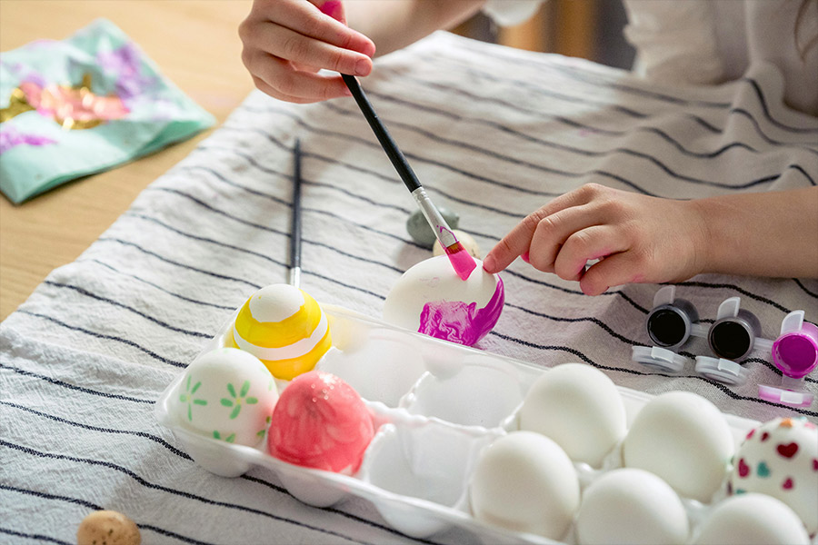Hands painting Easter eggs