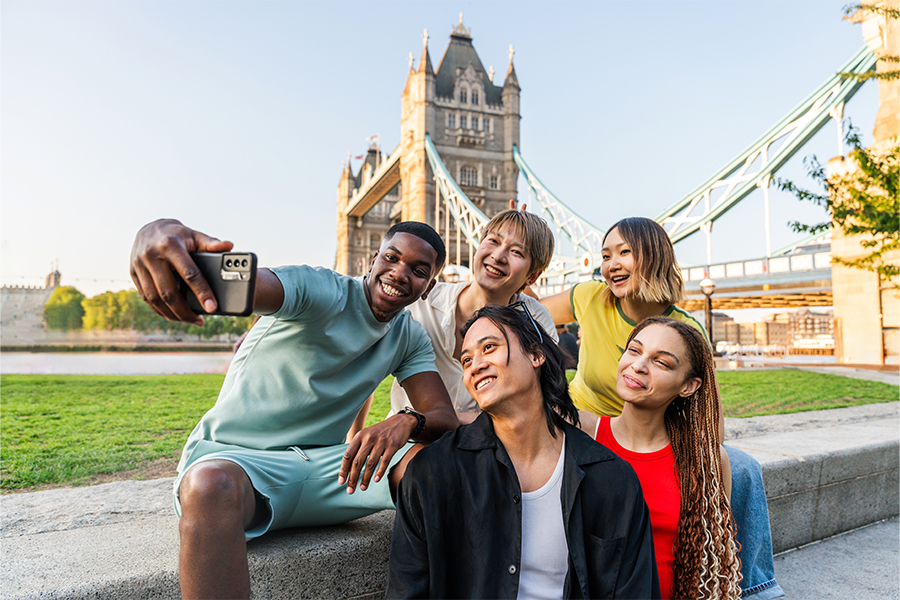 group of friends taking a selfie next to London Bridge