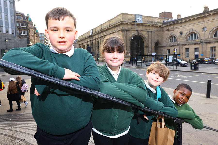 Four Broadwood School children in front of Newcastle Central station