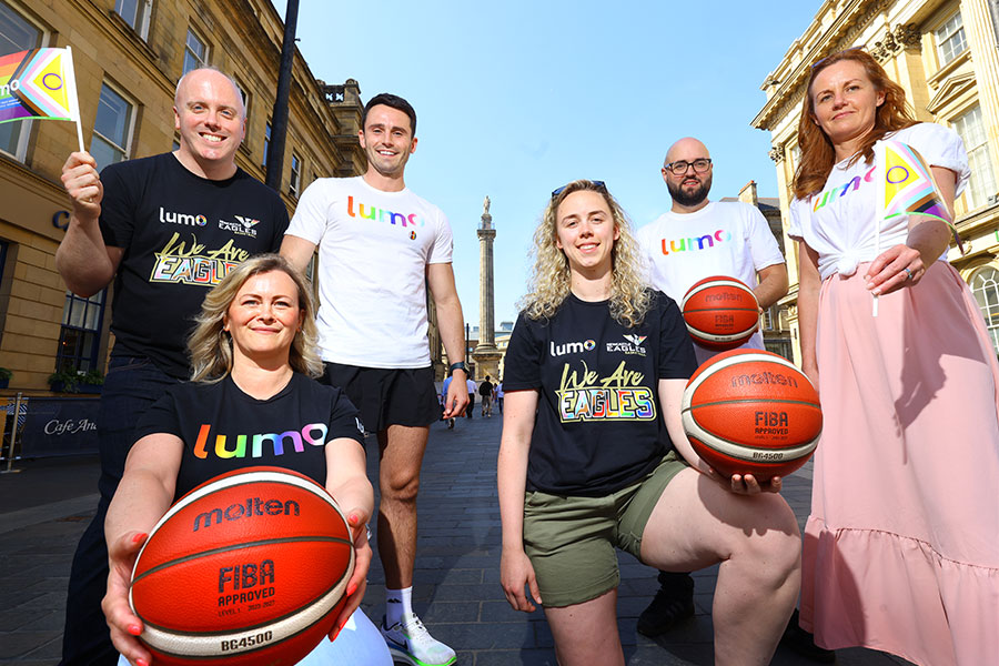 Lumo staff and Newcastle Eagles player waving pride flags