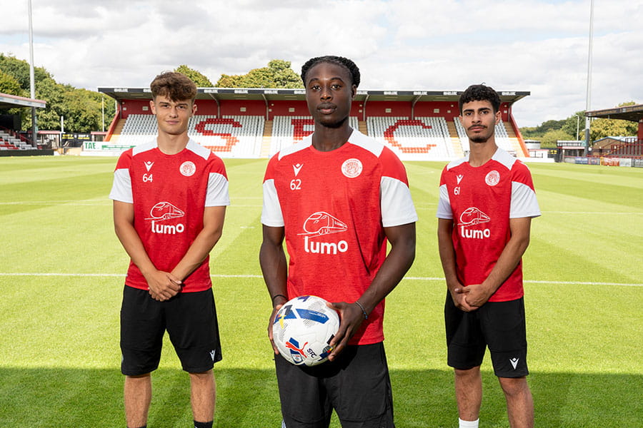 Three Stevenage FC players in the football pitch