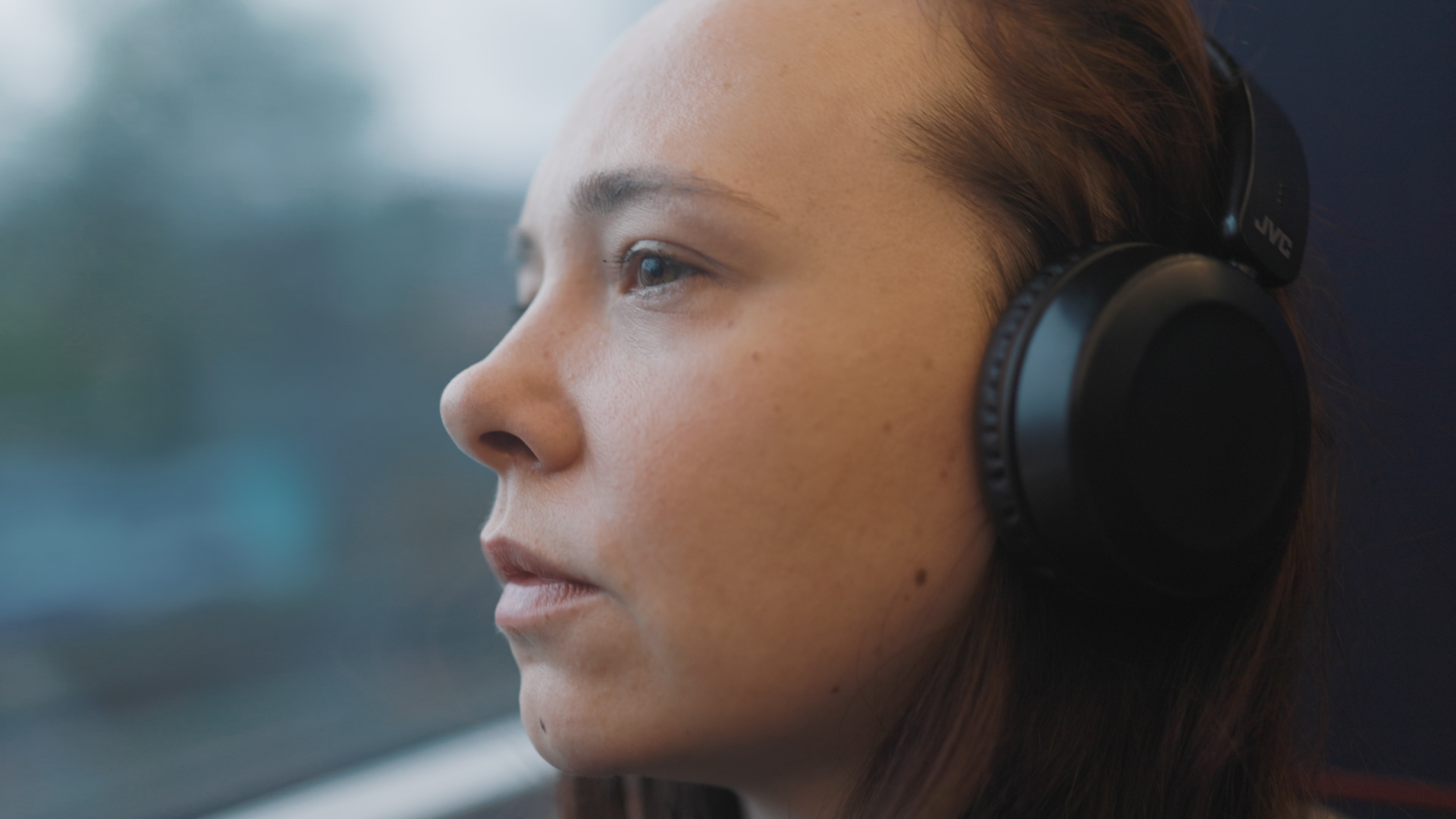 woman listening to music on headphones on Lumo train