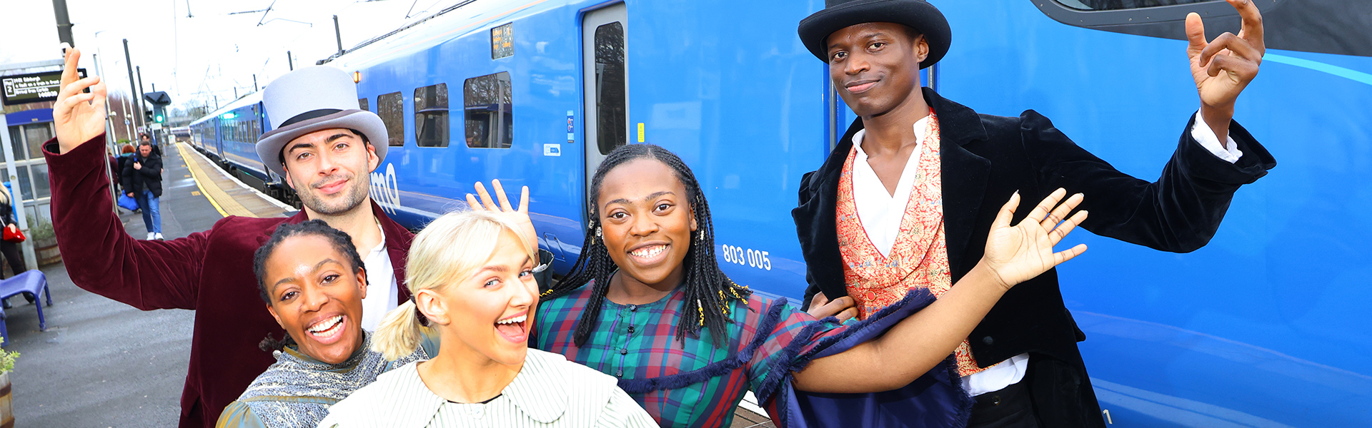 (L-R) Alicia McKenzie, Benjamin Storey, Emily Ash, Gigi Noel-King and Taku Mutero standing in front of a Lumo train