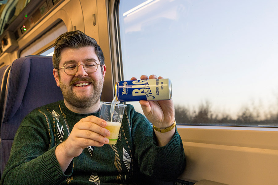 Reece Hugill, founder and Managing Director at Donzoko Brewing Company, filling a glass with beer on a Lumo train