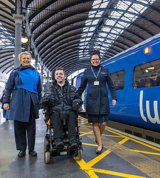 Two Lumo ambassadors assisting a customer with disabilities
