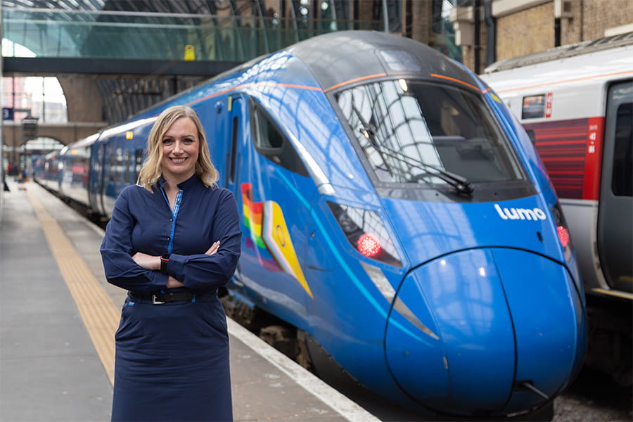 Sam Bentley, Customer Driver, at London King's Cross station next to a Lumo train
